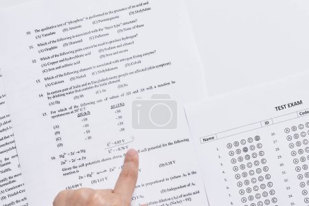 Téléchargez les photos : Une personne pointant à la main les numéros sur un morceau de papier imprimé pour utilisation - en image libre de droit