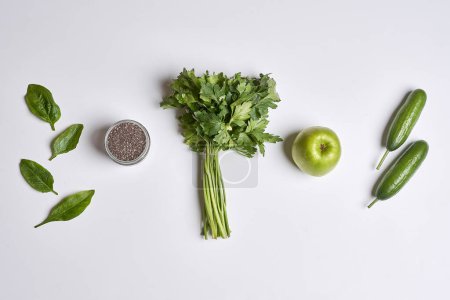 Foto de Some fruits and vegetables on a white surface with an apple, cus, avocal, celeron, green beans - Imagen libre de derechos