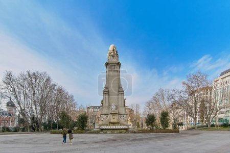 Photo for Madrid, Spain - June 03, 2023: Madrid, Spain - June 03, 2023: Couple looking at the back of the Miguel de Cervantes monument with the Isabel de Portugal fountain without water but normally running - Royalty Free Image