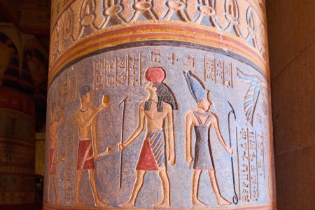 Téléchargez les photos : Gros plan de la colonne égyptienne avec des hiéroglyphes et trois figures très colorées sur fond bleu. - en image libre de droit