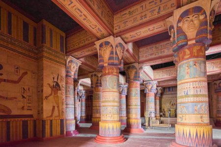 Téléchargez les photos : Le temple égyptien, avec de hautes colonnes et des dessins complexes, abrite des sculptures d'Hathor. Les murs et le plafond sont pleins de hiéroglyphes. La photo montre une vue vers le haut du temple faiblement éclairé. - en image libre de droit