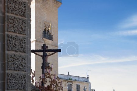 Foto de Imagen captada durante la Semana Santa en Jerez de la Frontera, España, mostrando una cruz adornada frente a la catedral bajo un cielo azul claro. - Imagen libre de derechos