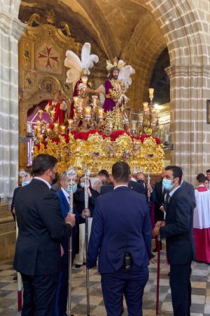 Foto de Jerez de la Frontera, España - 17 de febrero de 2024: Procesión religiosa en la Catedral de Jerez, España, durante la Semana Santa, mostrando devotos y un pasaje elaborado. - Imagen libre de derechos