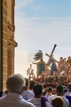 Foto de Jerez de la Frontera, España - 16 de febrero de 2024: Grupo de personas detrás de un paso durante la Semana Santa saliendo de la Catedral de Jerez, España. - Imagen libre de derechos