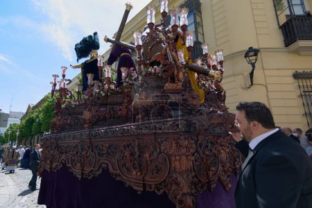 Foto de Jerez de la Frontera, España - 18 de febrero de 2024: Procesión de Semana Santa en Jerez, con una hermandad iluminada por la luz del atardecer. - Imagen libre de derechos