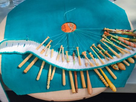 Image d'un métier à main en cours de fabrication avec des fils colorés étirés. Un outil de tissage artisanal qui montre la beauté du travail manuel et de la tradition textile.