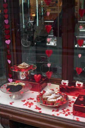 Foto de Vitrina adornada con corazones, mostrando dulces y regalos temáticos de San Valentín, ideal para expresar amor y aprecio. - Imagen libre de derechos