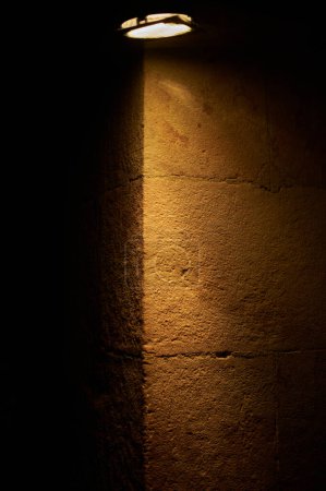 Ein helles Licht erhellt eine dunkle Wand und schafft einen dramatischen Kontrast und eine geheimnisvolle Atmosphäre mit Platz für Text