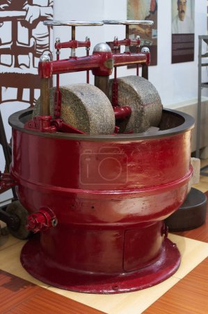 Close-up of an antique machine used in the chocolate making process, showing worn gears and mechanisms.