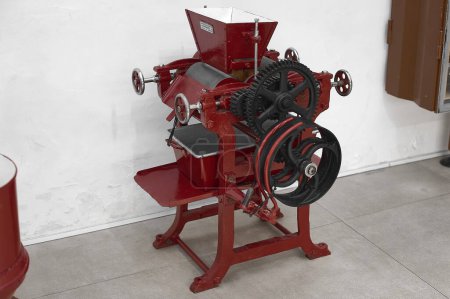 Nahaufnahme einer antiken Maschine zur Schokoladenherstellung, die verschlissene Zahnräder und Mechanismen zeigt.