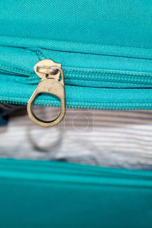 Blauer Koffer geöffnet, Kleidung für eine Reise bestellt.