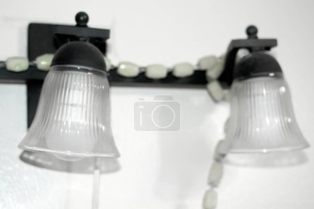 Téléchargez les photos : Deux lampes suspendues en verre avec ornements, idéales pour les intérieurs modernes et classiques avec une partie d'un chapelet religieux. - en image libre de droit