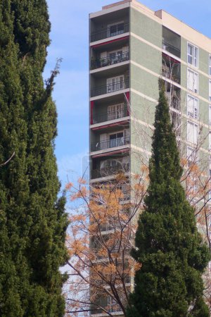 Einfangen einer modernen Wohnanlage an einem klaren Tag, mit Herbstbäumen, die dem Stadtbild einen Hauch von Natur verleihen.