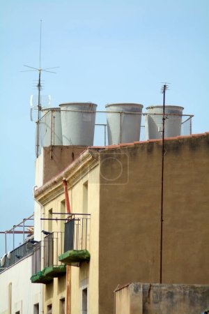 Das Bild zeigt eine einzigartige Kombination aus Nutzwert und Architektur, mit Wassertanks auf dem Dach
