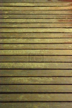 Aged wooden surface with prominent parallel lines offering a textured background ideal for a rustic and natural setting.