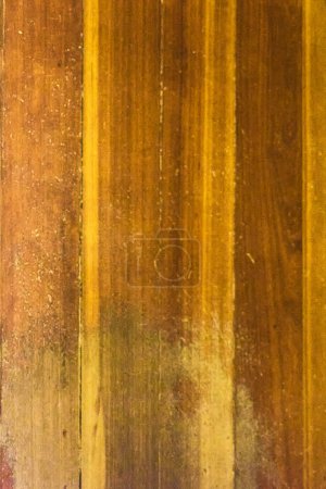 A close-up of weathered wood planks arranged vertically, revealing a detailed texture rich with variations in color and tone.