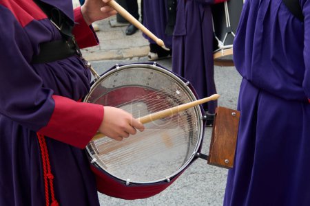 Músicos tocando la batería durante una procesión. Están vestidos con túnicas coloridas que crean una atmósfera vibrante y rítmica que invita a la reflexión y la celebración.