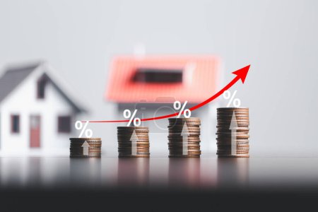 Stacks of coins and model house with percentage symbol for increasing interest rates. Interest rate financial and mortgage rates. Icon percentage symbol and arrow pointing up. Home price or increase.