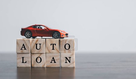 Photo for The word AUTO LOAN in the English language, written on wooden cubes. Finance and car loan, refinance, Investment and business concept with copy space. - Royalty Free Image