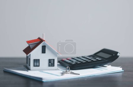Photo for Key with model home on wooden table, Save money concept, Property investment, house loan, reverse mortgage, gold coins money stack growth, saving money coins stack future for home - Royalty Free Image