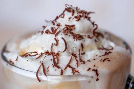 Photo for Close up of white whipped cream foam on a coffee latte in a glass cup, grated chocolate chips. Copy space. High quality photo - Royalty Free Image