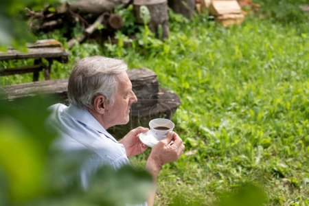 Homme âgé sirotant du thé, avec un accent sur la détente et la simplicité de profiter de la nature, idéal pour les loisirs et la retraite, concepts d'assurance aînés. Photo de haute qualité