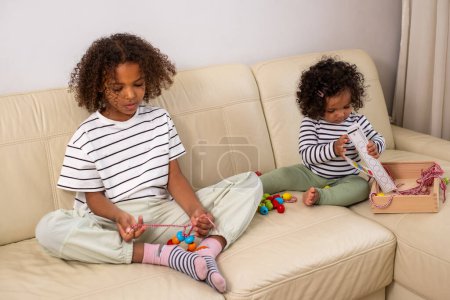 Two African American girls are absorbed in play with development provocative toys. engagement, and interest in learning perfect for kid occupation ideas. . High quality photo