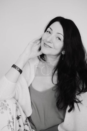 A black and white picture of a Serene mature woman, black hair, embodies grace amidst midlife change. for narratives on navigating menopause with positivity, and hormonal changes. High quality photo