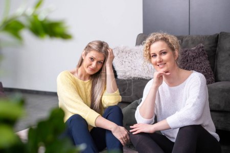 Two woman sit next to each other and look at the camera, symbolizing companionship in mental care, and therapy, wellness themes. High quality photo