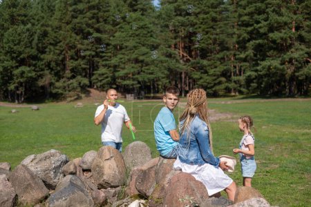 A family enjoys an outdoor adventure in a pine forest clearing, This picture encapsulates the spirit of childhood play and family escapades in nature. High quality photo