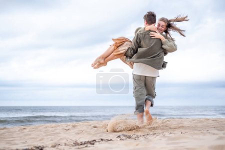 A young couple shares a joyful moment, man caring his bride both happy, their happiness as boundless as the sea behind them, celebrating love, engagements, or moments together. High quality photo