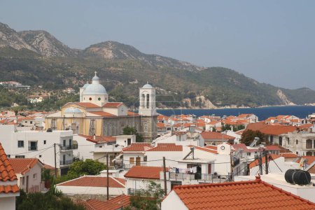 Foto de Una vista de los tejados de las casas y la Iglesia de San Nicolás en el pueblo pesquero griego de Kokkari en la isla de Samos. - Imagen libre de derechos