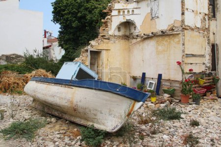 Foto de Parte de una casa en ruinas y un barco de pesca en el tradicional pueblo griego de Kokkaroi en la isla de Samos - Imagen libre de derechos