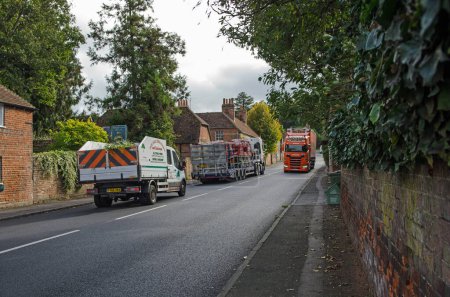 Foto de Aldermaston, Reino Unido - 27 de octubre de 2021: Tres camiones pasan por el bonito pueblo de Aldermaston en Berkshire en una tarde de otoño. - Imagen libre de derechos