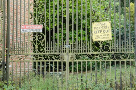 Foto de Vista desde la calle de algunas puertas históricas. Encadenado cerrado con propiedad privada y sin señales de advertencia de entrada ilegal. Aldermaston Court, Berkshire. - Imagen libre de derechos