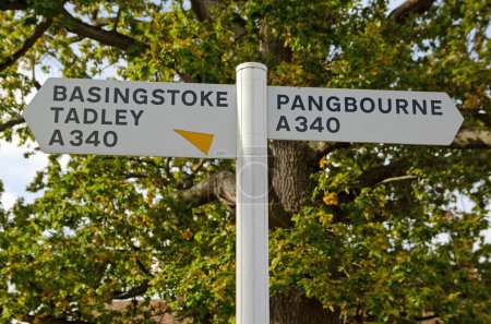 Téléchargez les photos : Panneau de signalisation en plastique blanc sur la route principale A340 à Aldermaston, Berkshire. Le village est situé entre Basingstoke et Pangbourne. Vue sur un après-midi ensoleillé d'automne. - en image libre de droit