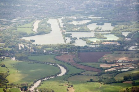 Téléchargez les photos : Vue aérienne des lacs Caversham sur la Tamise avec la ville de Reading au loin. La rivière forme la frontière entre les comtés d'Oxfordshire et de Berkshire. Visionné un après-midi de printemps. - en image libre de droit