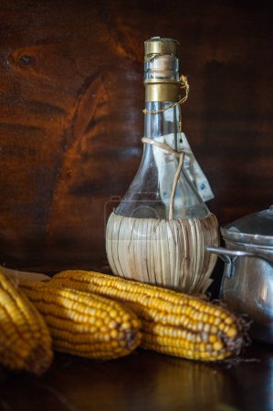 Photo for Corn and wine flask on table - Royalty Free Image