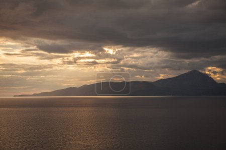 Téléchargez les photos : Tempête de mer au coucher du soleil avec derrière l'île - en image libre de droit