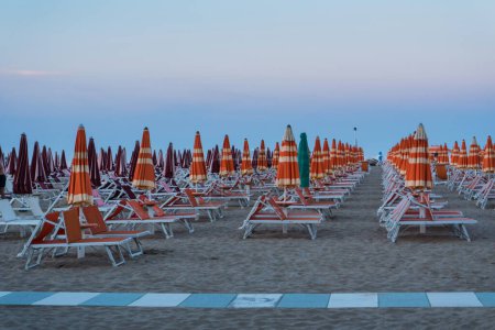 Téléchargez les photos : Parasols fermés sur la plageet chaises longues - en image libre de droit