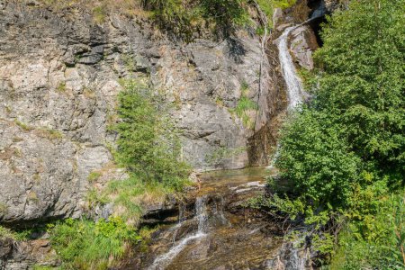 Photo for Stream flows among the rocks and creates an alpine waterfall - Royalty Free Image