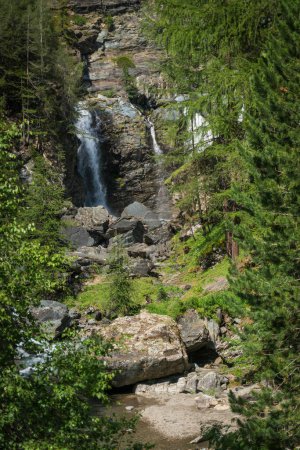 Photo for Stream flows among the rocks and creates an alpine waterfall - Royalty Free Image