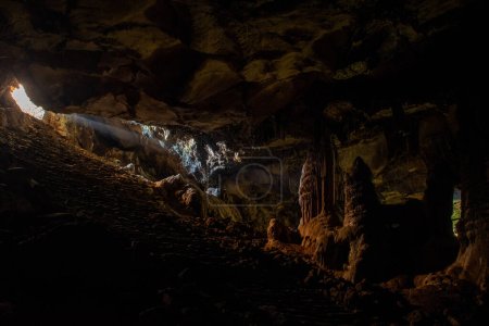 Téléchargez les photos : Grotte éclairée par les rayons du soleil entrant et éclairant la chambre centrale - en image libre de droit