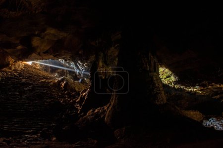 Photo for Sunbeams inside the cave. From the cave entrance, sunbeams illuminate the interior. - Royalty Free Image