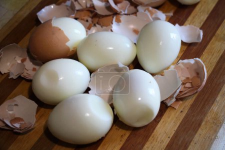 Photo for On the kitchen board, hard-boiled chicken eggs are peeled - Royalty Free Image