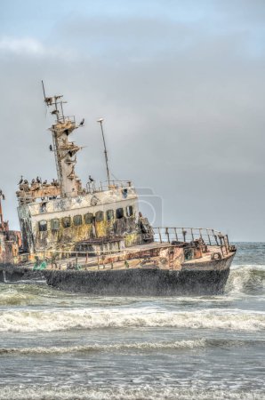 Téléchargez les photos : The thrown old ship has sat down on a bank - Namib desert with Atlantic ocean meets near Skeleton coast - Namibia, South Africa - en image libre de droit