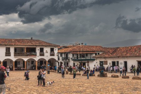 Téléchargez les photos : Villa de Leyva, Colombie - 20 avril 2019 : Les touristes séjournent sur la place de la ville historique par temps nuageux. - en image libre de droit