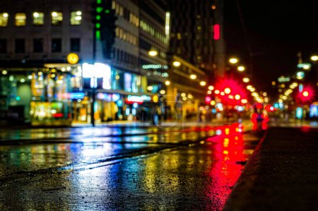 Blick auf die nasse Stadtstraße bei Nacht