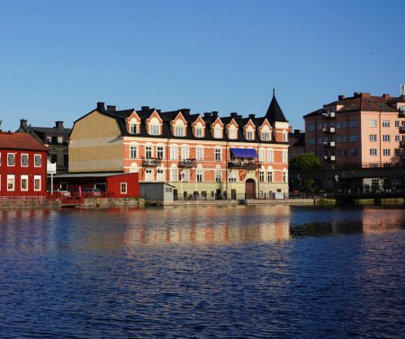 Téléchargez les photos : Vue des bâtiments au bord de la rivière contre ciel bleu - en image libre de droit
