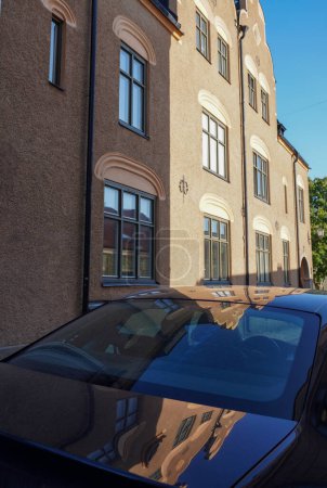 Téléchargez les photos : Vue voiture garée à l'extérieur du bâtiment résidentiel contre le ciel - en image libre de droit